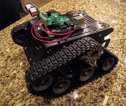 Image of Devastator chassis, controller board, a motor control expansion board, and an ultrasonic sensor