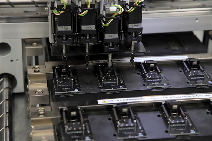 Image of DigiKey's automated programming machine placing a blank oscillator in one of the programming sockets (Image source: DigiKey)